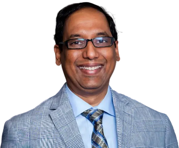 A man wearing glasses, a checked light gray suit jacket, a blue dress shirt, and a patterned tie, smiling at the camera—exuding confidence and expertise in AI and data strategy.